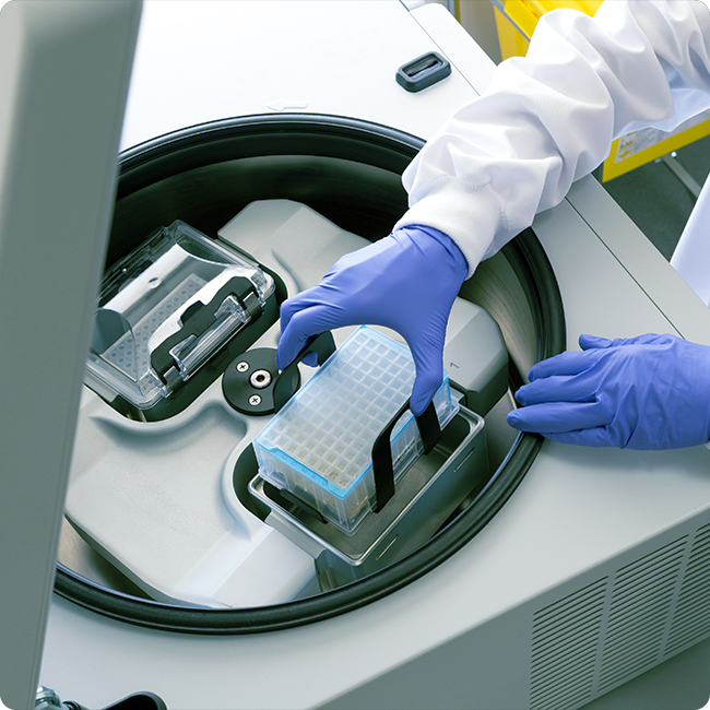 closeup shot of a lab workers hands in purple gloves handling futuristic medical equipment