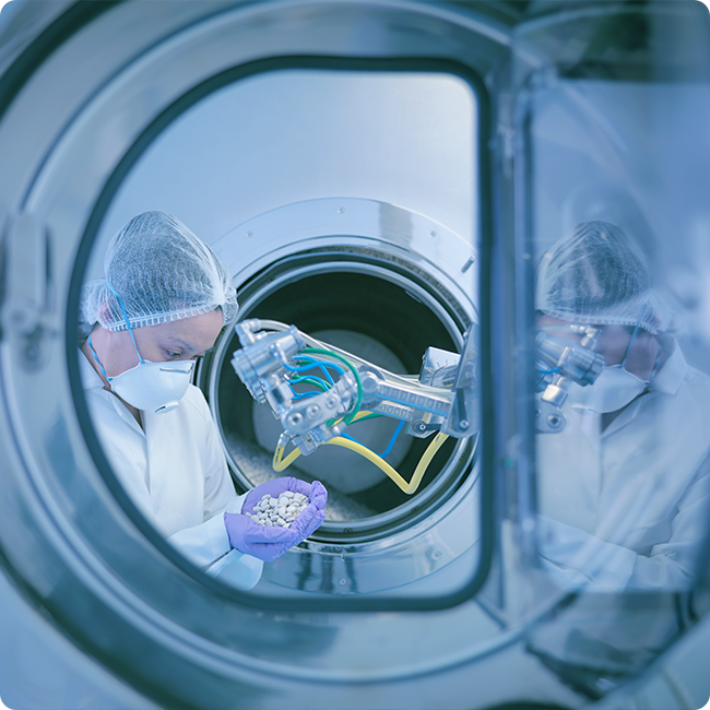 biotechnology innovation represented by a female lab worker holding pills next to a robot seen through an open door of a machine