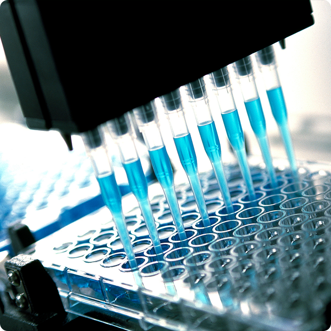 closeup shot of a medical machine filling clear vials with a blue liquid